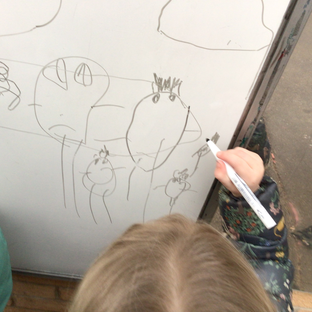 child drawing on whiteboard